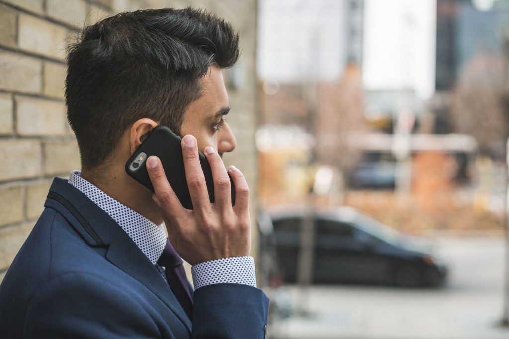 Professional man in suit making a phone call outside in city setting. — Balancing Personal Passions and Professional Excellen