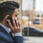 Professional man in suit making a phone call outside in city setting. — Balancing Personal Passions and Professional Excellen