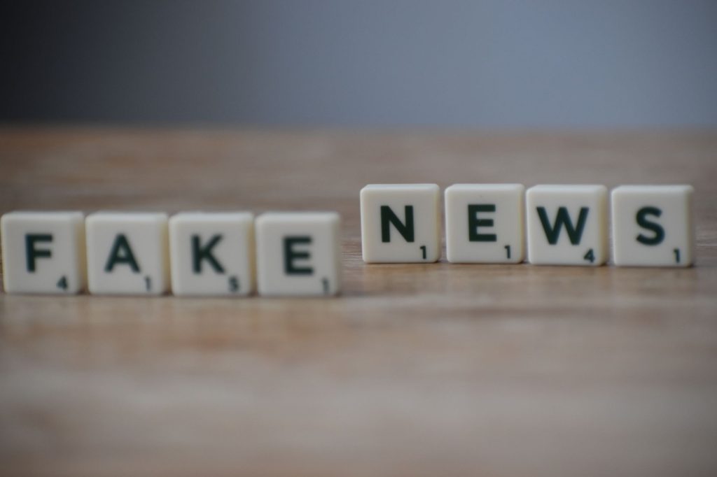 Scrabble tiles spelling 'Fake News' on a wooden surface highlighting misinformation. — Best CDL Class A Online Course