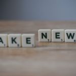 Scrabble tiles spelling 'Fake News' on a wooden surface highlighting misinformation. — Best CDL Class A Online Course