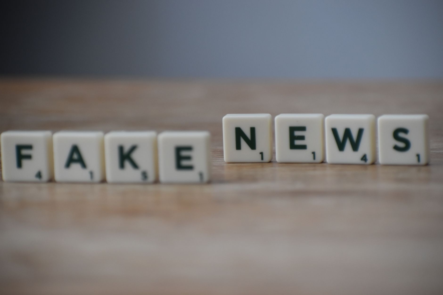 Scrabble tiles spelling 'Fake News' on a wooden surface highlighting misinformation. — Best CDL Class A Online Course
