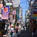Bustling urban street in Osaka with colorful advertisements and pedestrians in daylight. — Beyond Dentistry: Dr Paul Carey 's