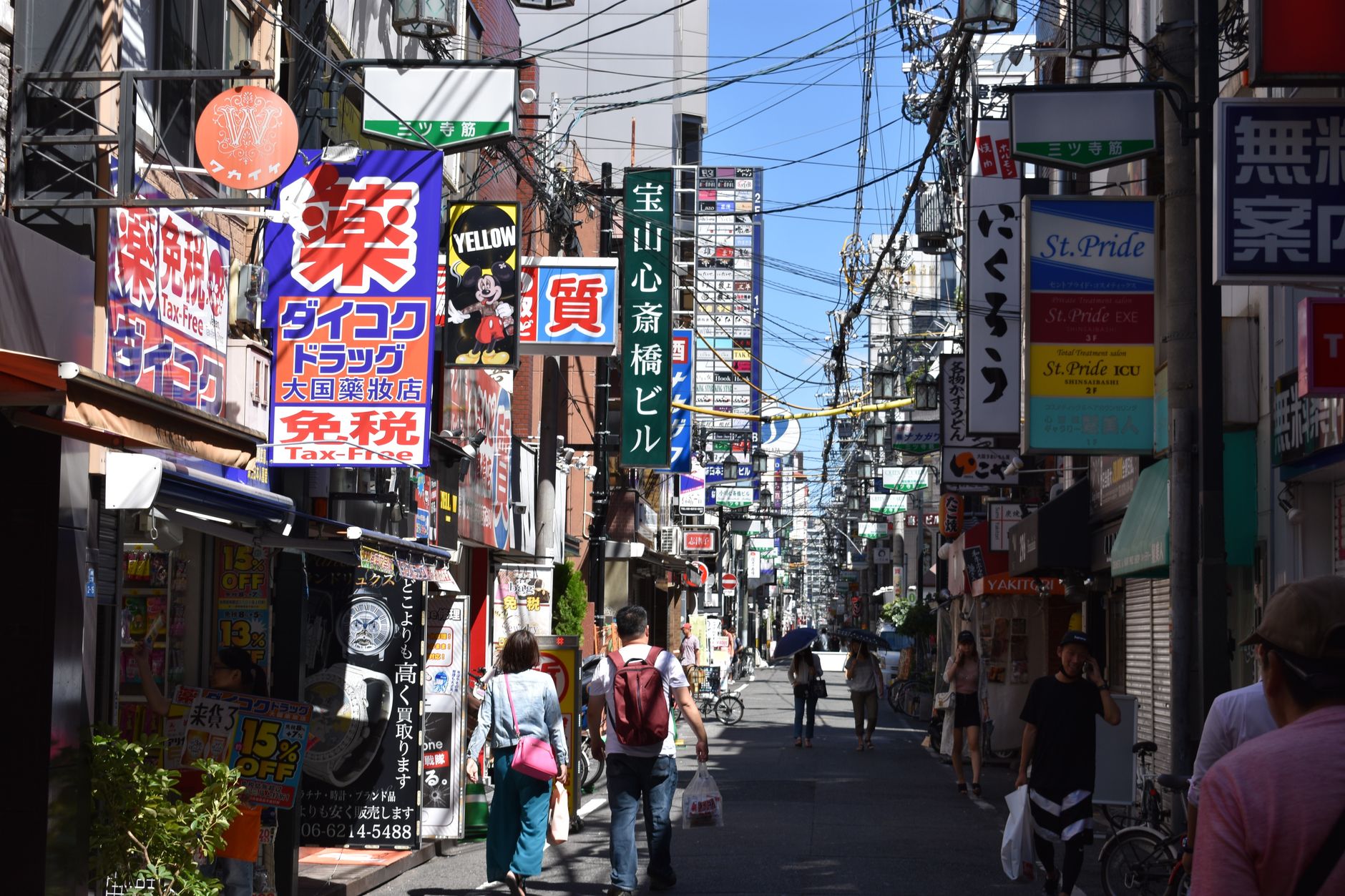 Bustling urban street in Osaka with colorful advertisements and pedestrians in daylight. — Beyond Dentistry: Dr Paul Carey 's