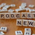 Wooden letter tiles spelling out 'PODCAST NEWS' on a wooden surface. — Chaos Engineering in Serverless: Building Resilient Sy