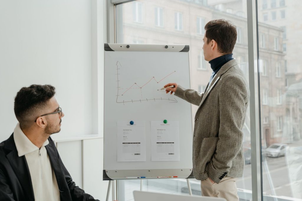 Two professionals examining graphs during an office presentation. — Dr. Andrew Gomes: Pioneering Advanced Neuroimaging in Tra