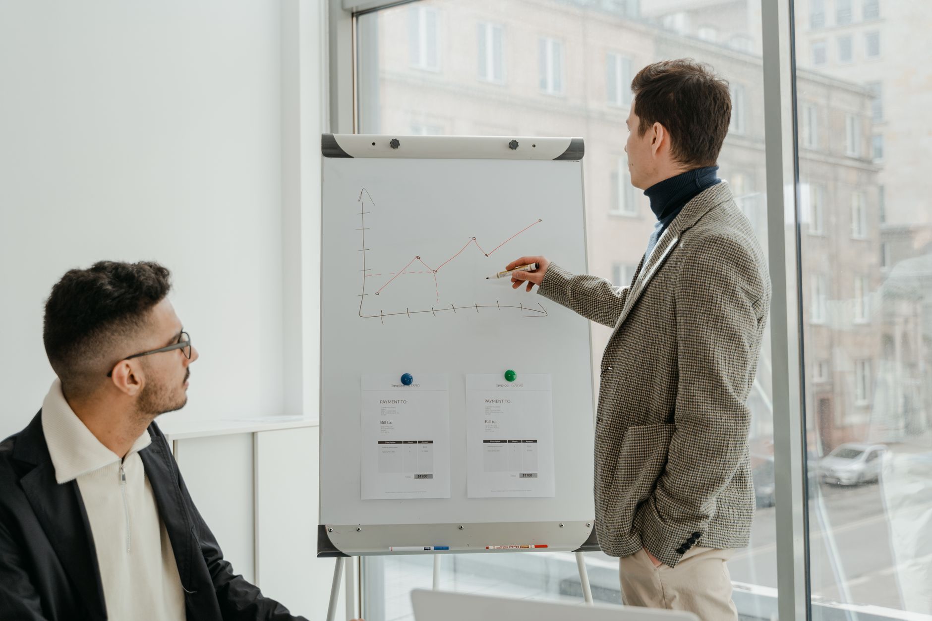 Two professionals examining graphs during an office presentation. — Dr. Andrew Gomes: Pioneering Advanced Neuroimaging in Tra