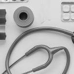 Top view of medical instruments and pills arranged on a white background. — Dr. Edward Lubin: Minimizing Medication While Max