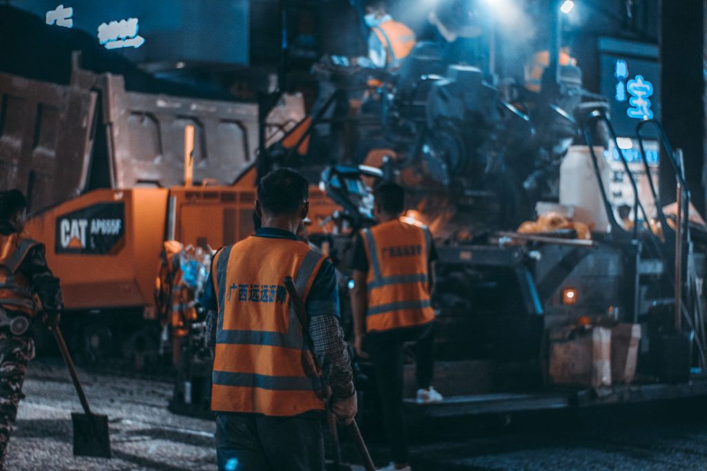 Workers in safety vests operate heavy machinery at a night construction site. — Enhance Interior Styles Using Decorative Skir