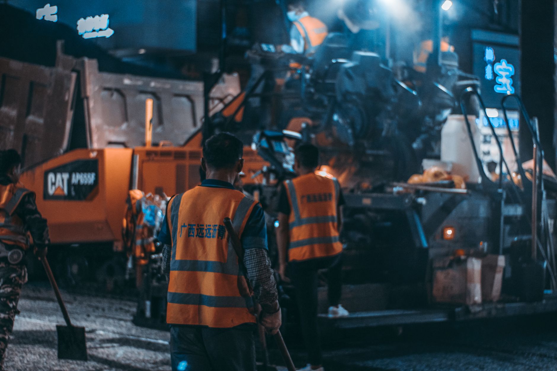 Workers in safety vests operate heavy machinery at a night construction site. — Enhance Interior Styles Using Decorative Skir