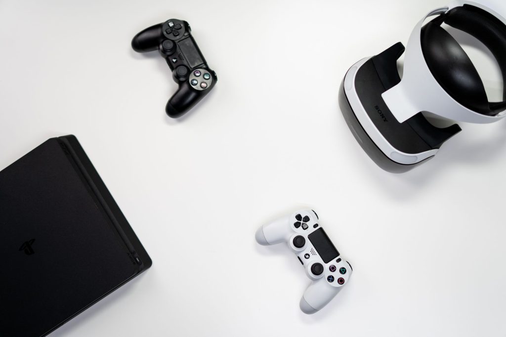 Flat lay of gaming console, controllers, and VR headset on a white background. — Find Secure and Verified Sources for TAG Gra