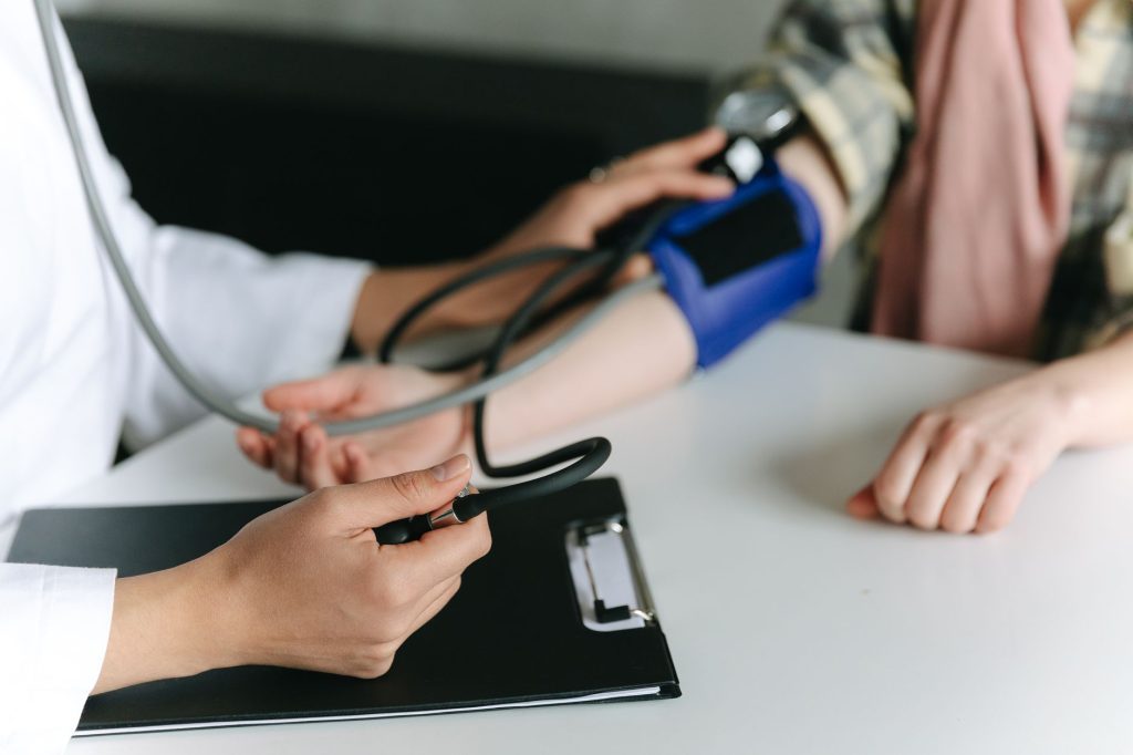 Close-up of a medical professional measuring a patient's blood pressure at a clinic. — Innovative Financial Strategies in Hea