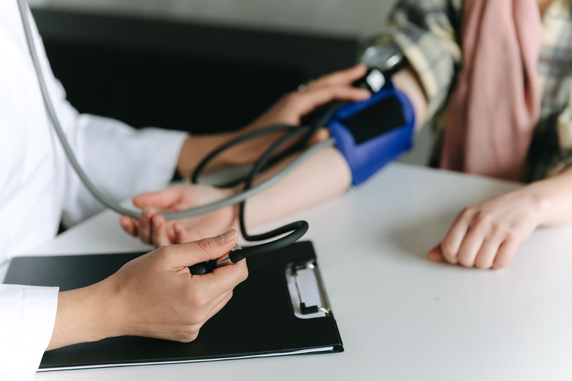 Close-up of a medical professional measuring a patient's blood pressure at a clinic. — Innovative Financial Strategies in Hea