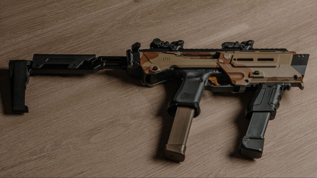 A close-up view of a tactical firearm with an adjustable brace setup on a wooden surface.