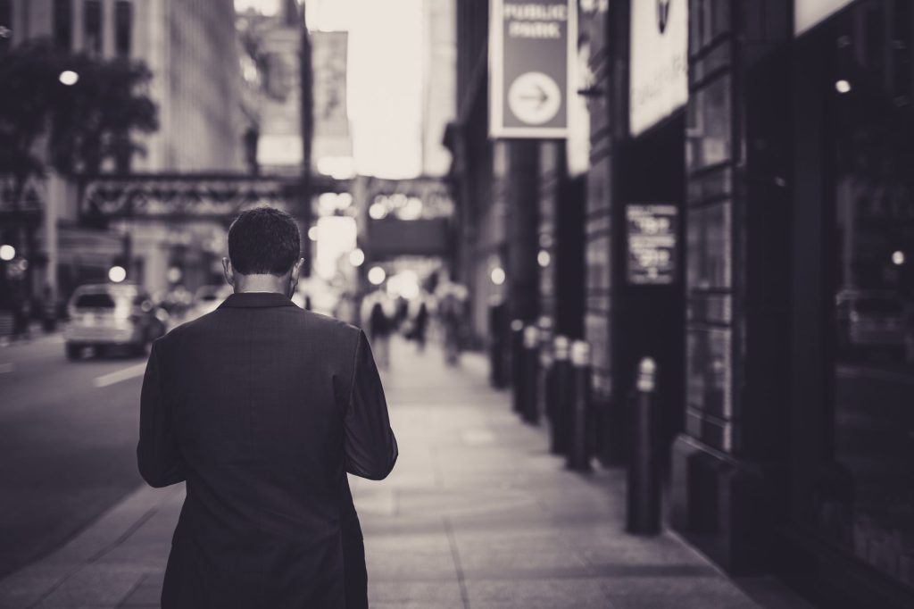 Man in a suit walking down a city street in a lonely, urban setting. — Martin Silver's Green Marketing Blueprint: Winning Cus