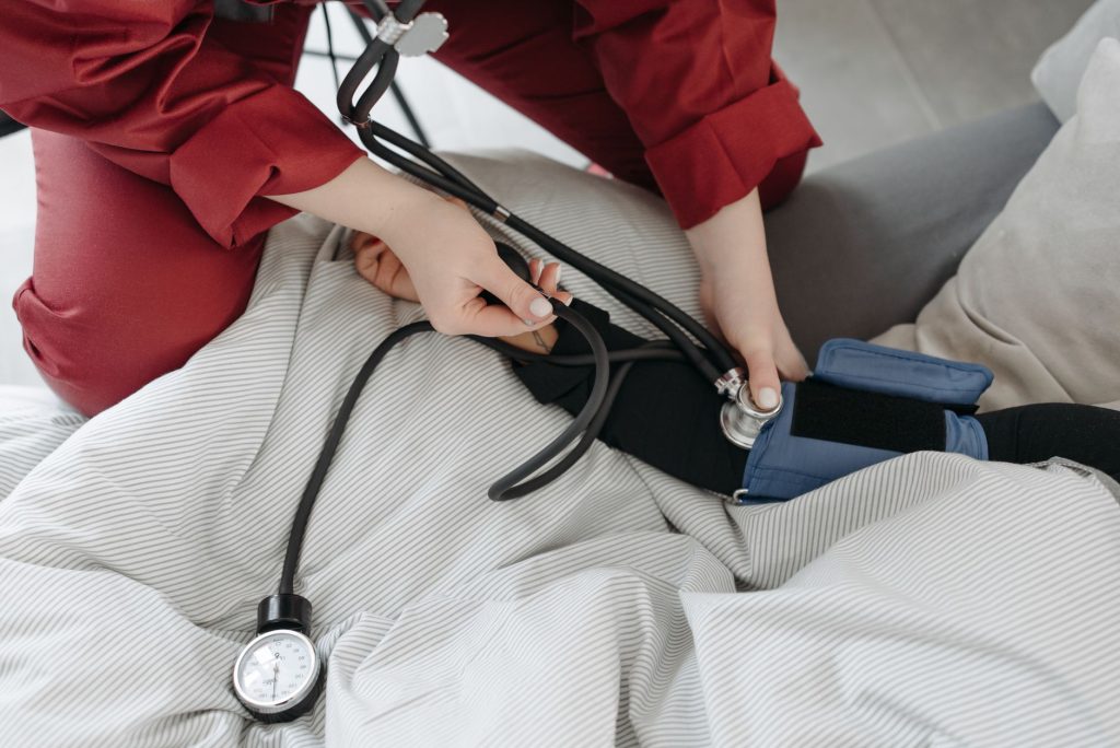 A medical professional checking a patient's blood pressure using a sphygmomanometer in a cozy setting. — Nangs: Fast and Effi