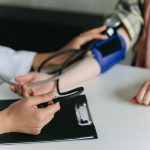 Close-up of a medical professional measuring a patient's blood pressure at a clinic. — Revolutionizing Hormonal Health: The R