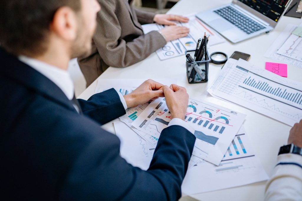 Business team analyzing financial graphs at a meeting table, fostering collaboration in an office environment. — Rose Sarfo: