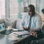 Two business professionals engaged in discussion over laptops and documents. — Sex Products for Confidence and Intimacy: A Gu