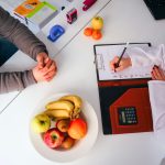Top view of a dietitian planning a healthy diet with fresh fruits on the table, focusing on health and nutrition. — The Dr He
