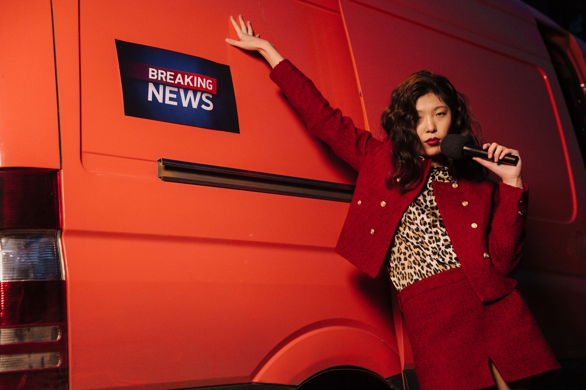 Fashionable reporter with microphone posing dramatically next to a news van. — The Ripple Effect of Koitoto Wins on Finances
