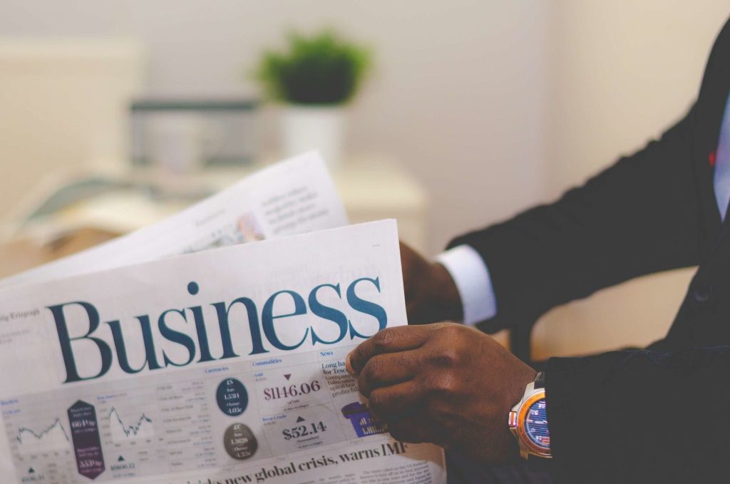 Close-up of a businessman reading a newspaper indoors, focusing on business headlines. — The Role of Litigation Expertise in