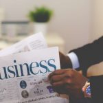Close-up of a businessman reading a newspaper indoors, focusing on business headlines. — The Role of Litigation Expertise in