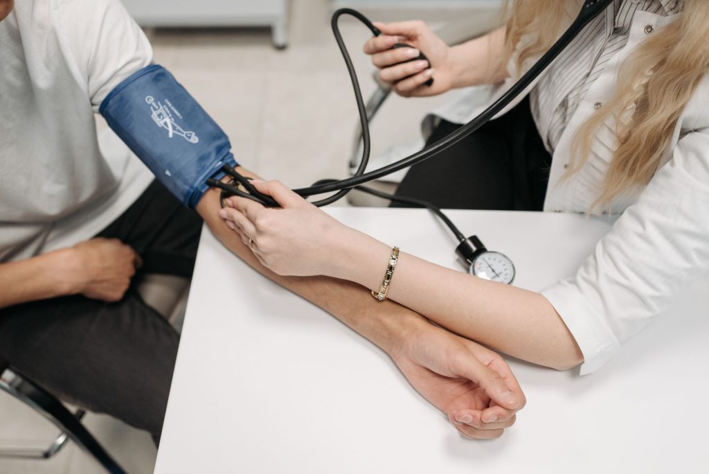 A doctor measures a patient's blood pressure with a sphygmomanometer during a consultation. — The Surgical Expertise and Exec