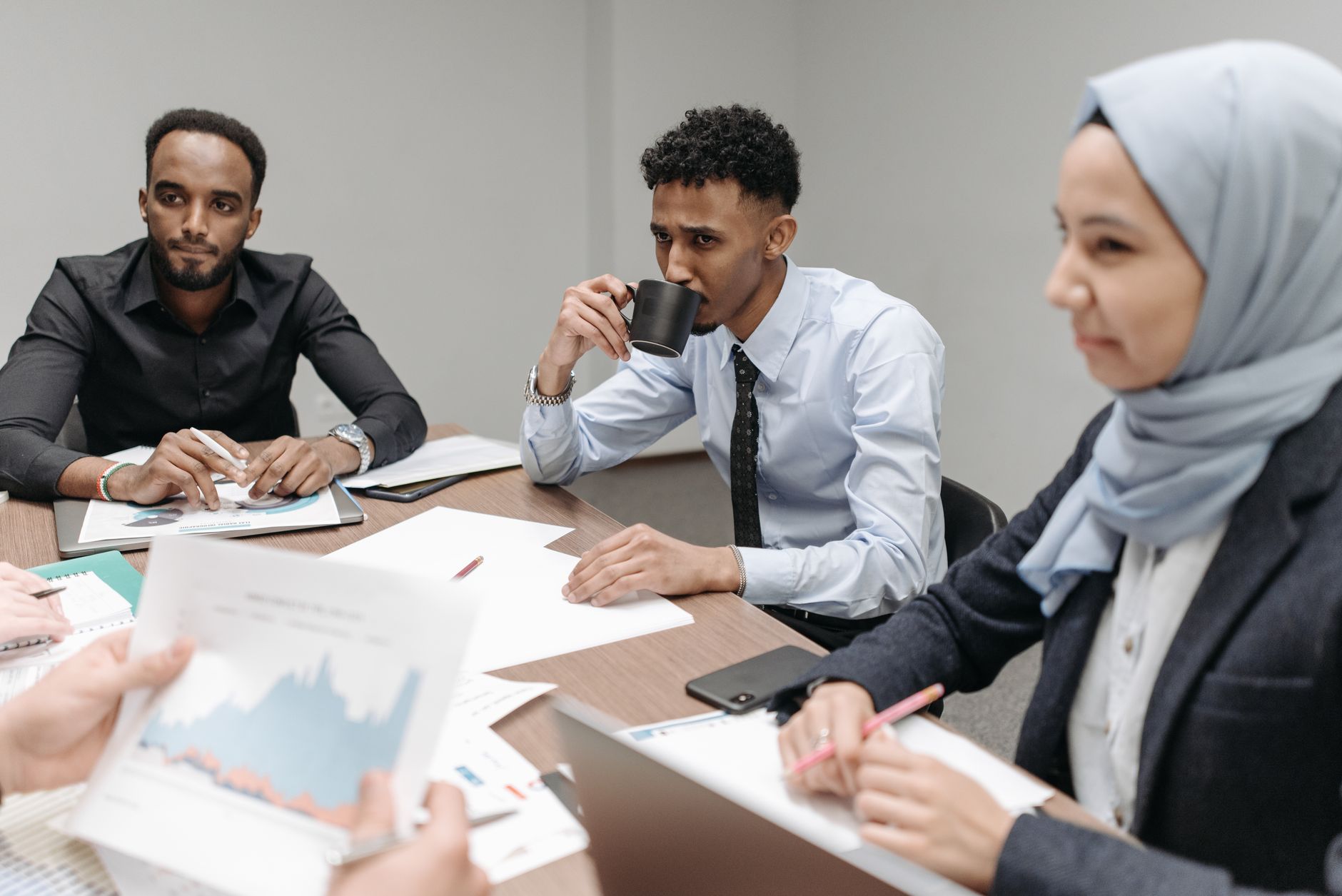 A multicultural team engaged in discussion during an office meeting, highlighting diversity and teamwork. — Travertine Pavers