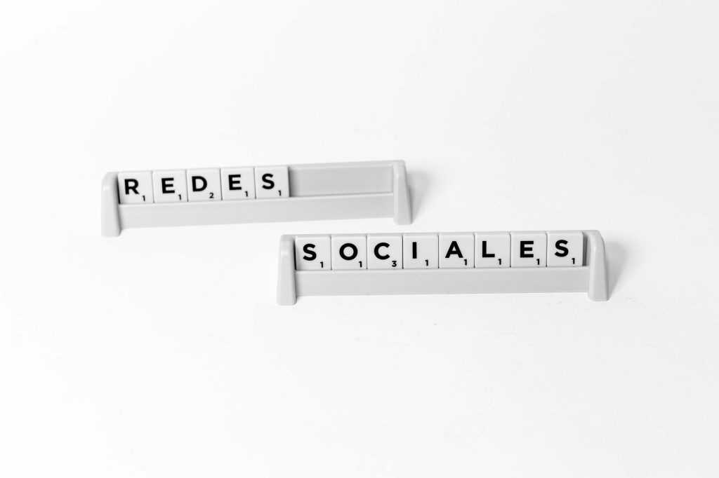 Scrabble tiles arranged to spell 'Redes Sociales', depicting social media on a white background. — View Pump Website enhances