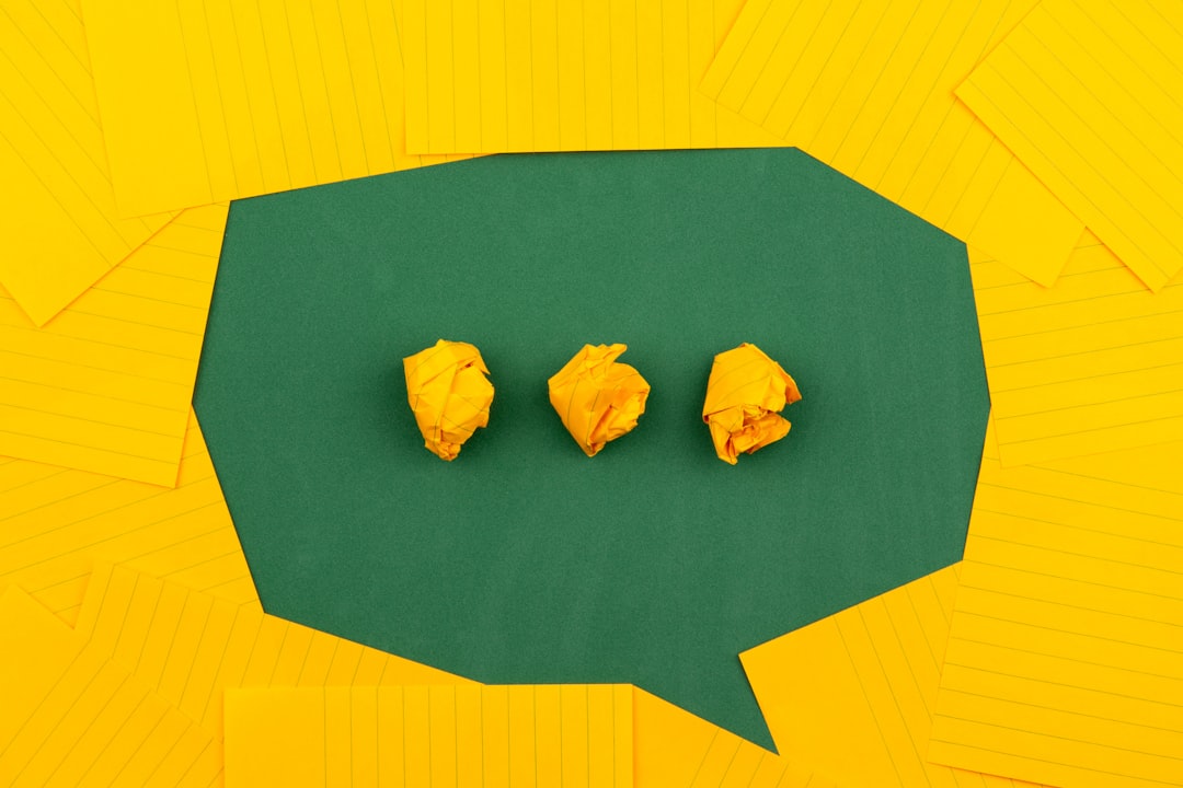 Crumpled yellow paper balls on a green background surrounded by lined paper, symbolizing chaotic thoughts.